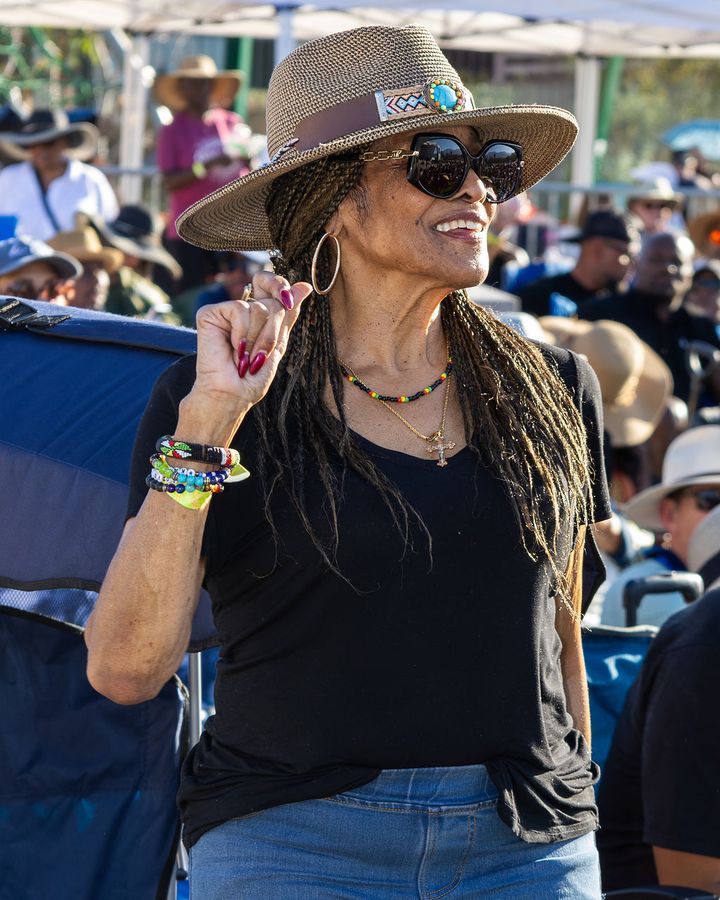 A guest in a wide-brimmed hat and sunglasses