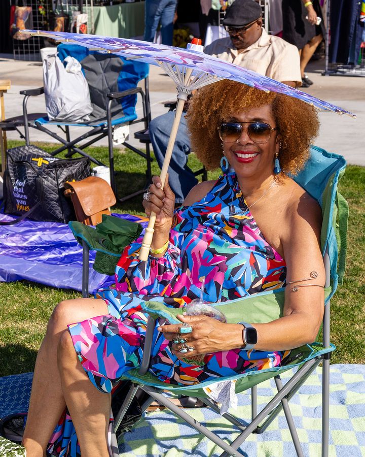 A guest in a bright print dress seated on the lawn
