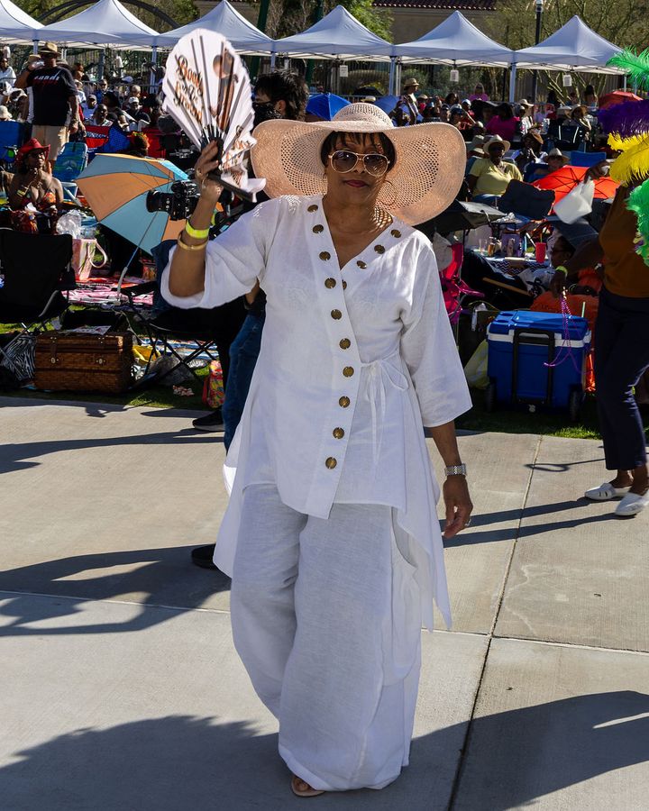 A guest in a white suit and hat