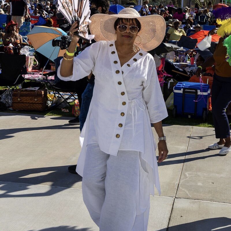 A guest walking the festival grounds dressed head to toe in white
