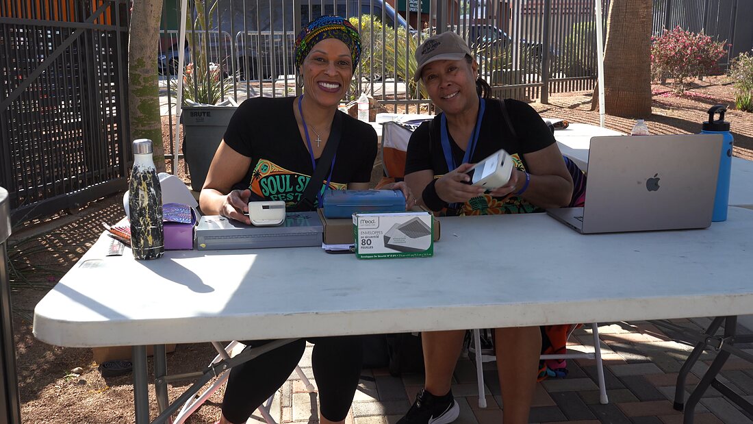 Two festival staff in Soul Springs tees working the check-in table