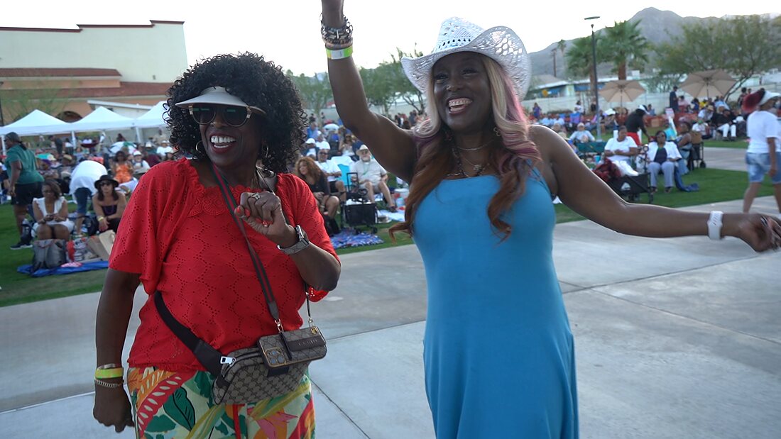 Two guests dancing toward the camera with their arms raised
