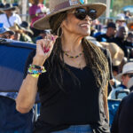 Woman in a stylish sun hat smiling at Soul Springs Festival