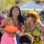 Two women in colorful beads dancing together at Soul Springs Festival