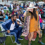 Woman dancing in an orange dress and boots among the crowd at Soul Springs Festival