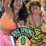 Two women celebrating with beaded necklaces at Soul Springs Festival